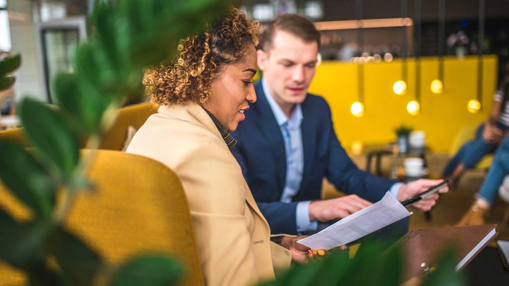 two-colleagues-working-in-a-cafe-looking-at-documents