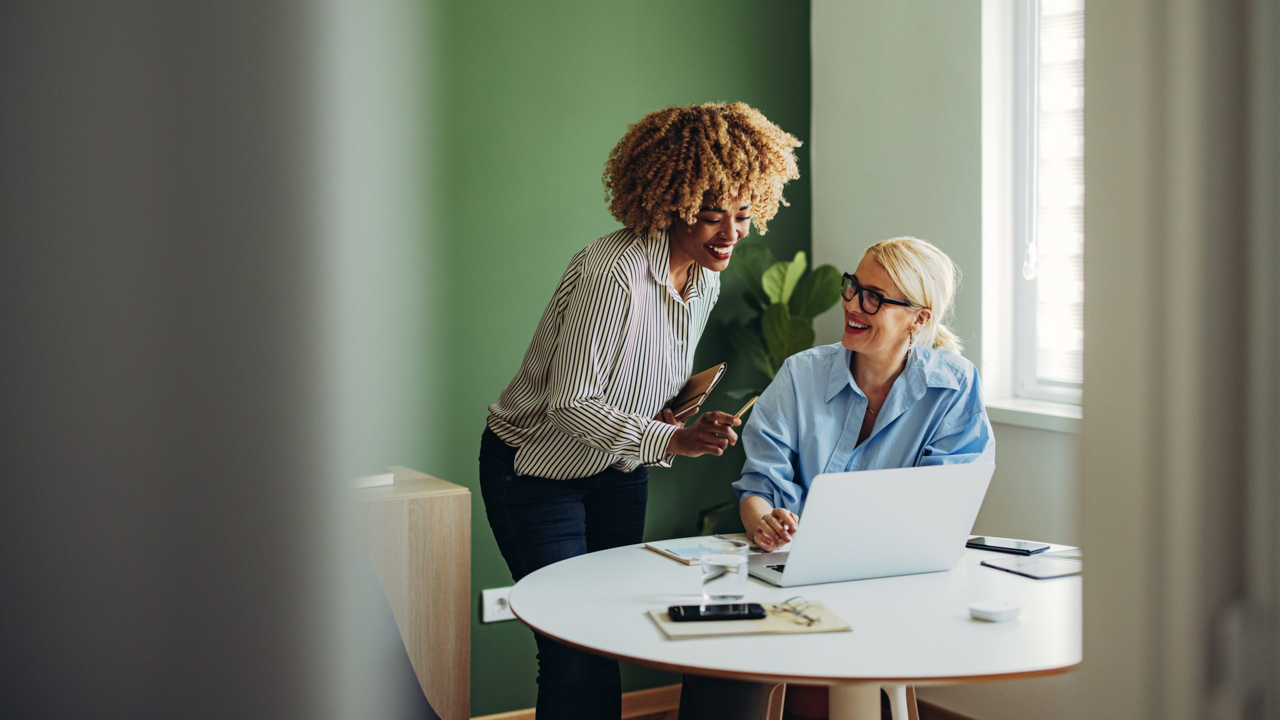 Two ladies looking at desk with laptop