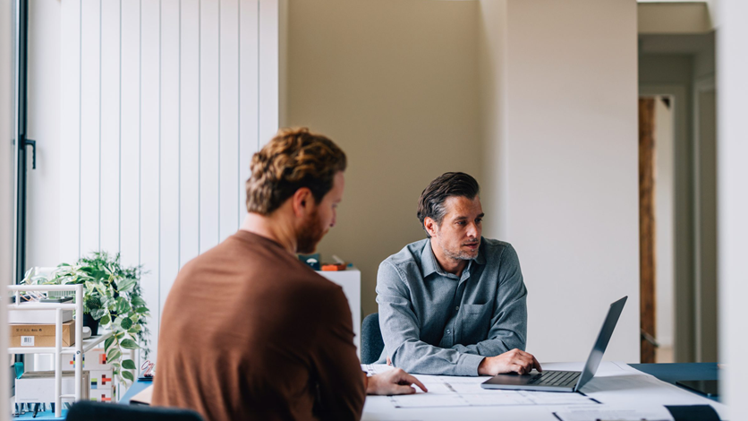 two men in a business meeting looking at laptop