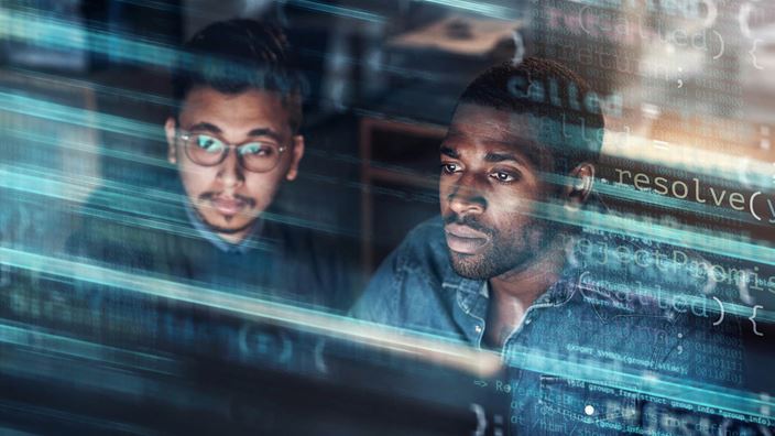 Two men looking at codes on screen