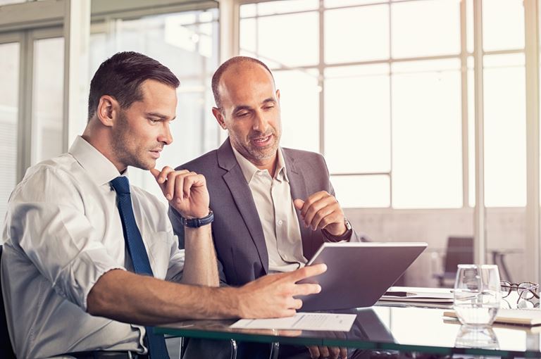 Two men looking at ipad in office