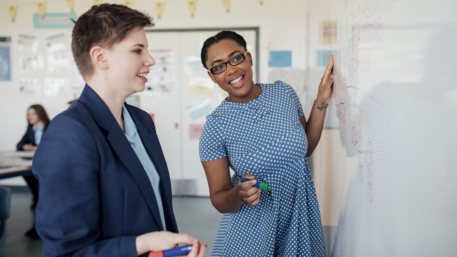 two women working on whiteboard