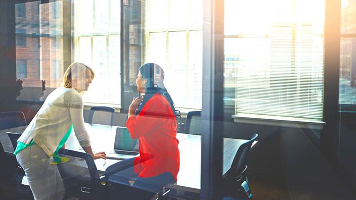 two women talking in meeting room
