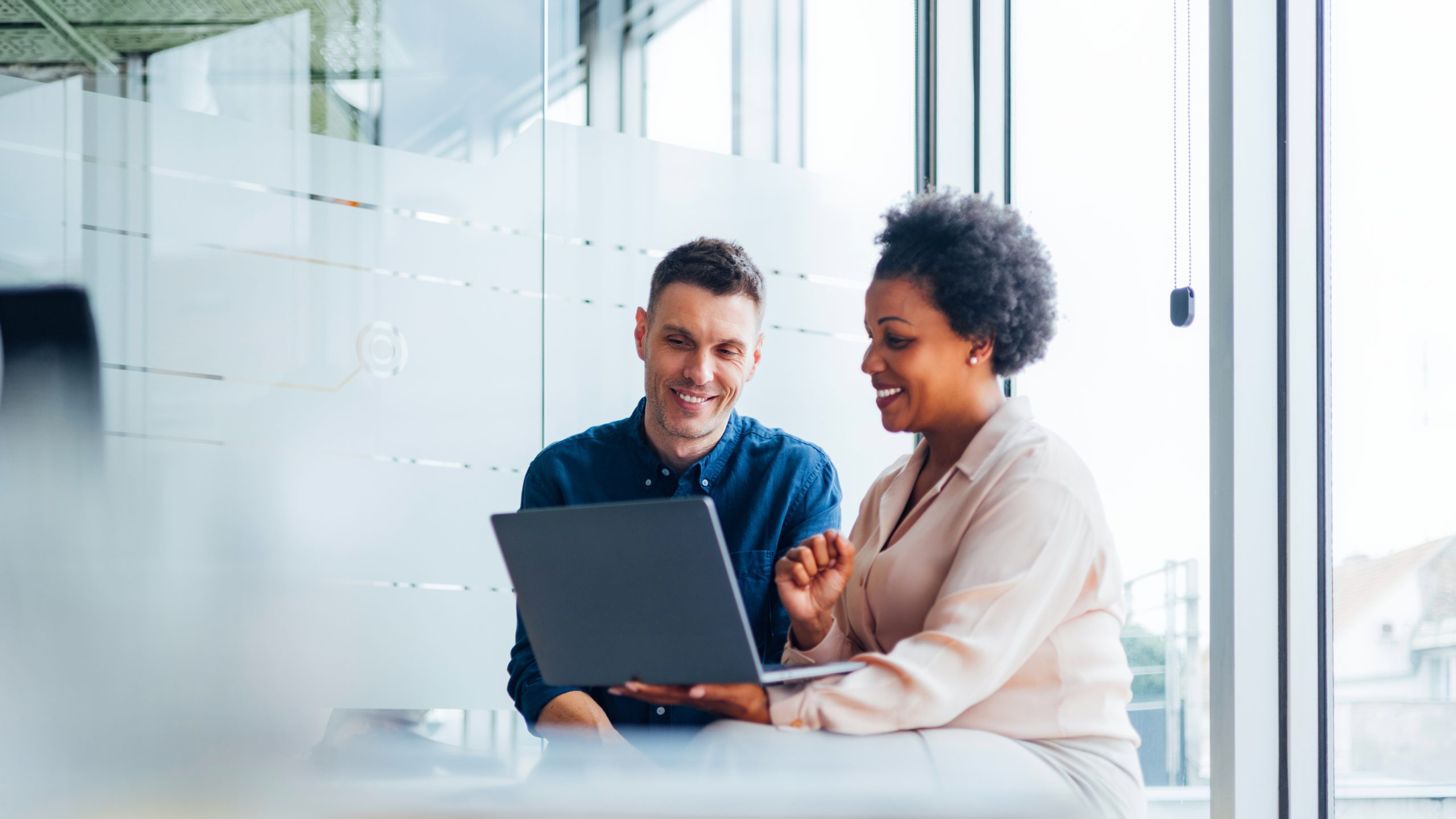 woman and man looking at laptop in the office