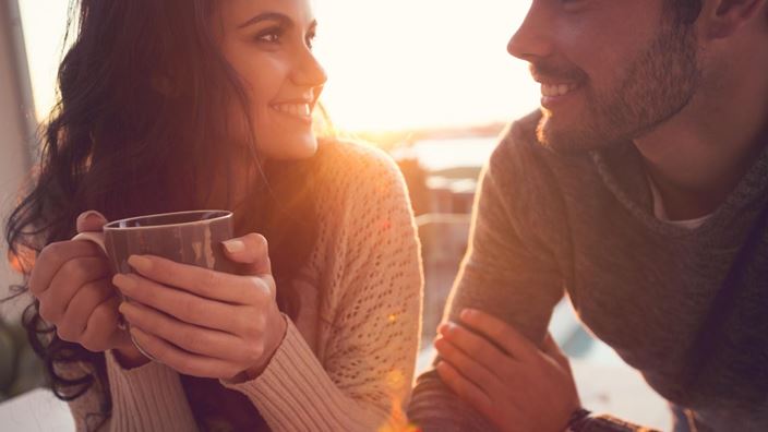 Woman and man smiling with mug