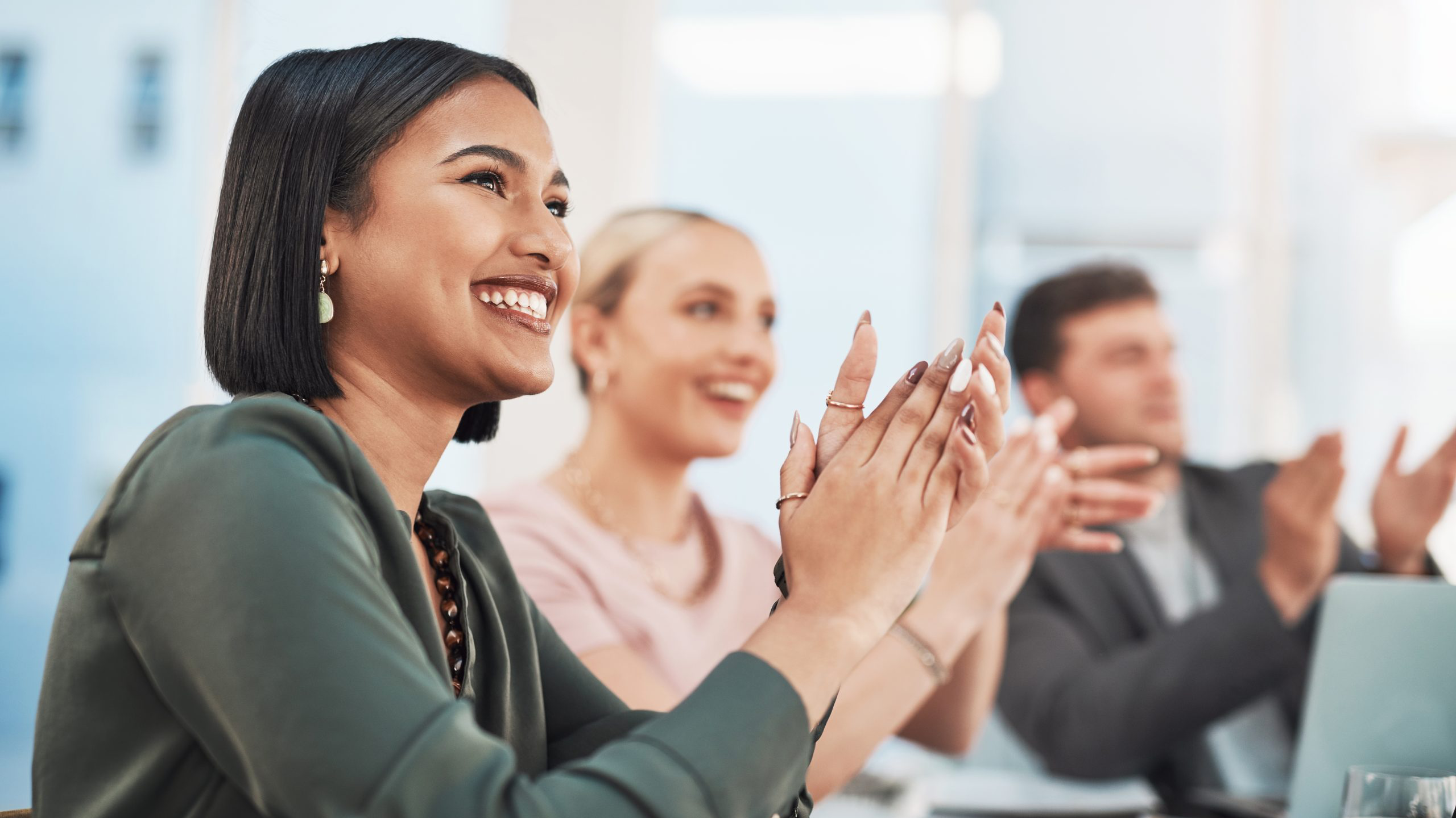 woman clapping in a meeting with colleagues