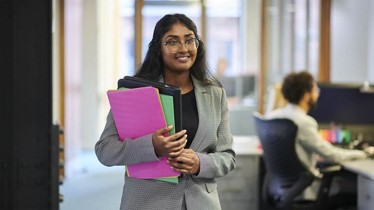 woman holding folders smiling