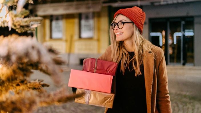 Woman holding wrapped boxes outside