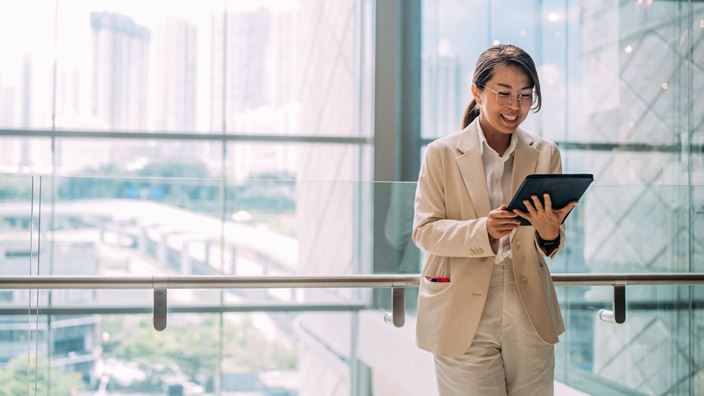 woman in glass office on tablet