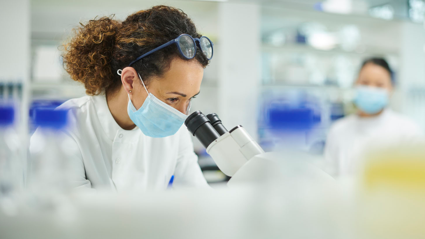 woman looking through microscope