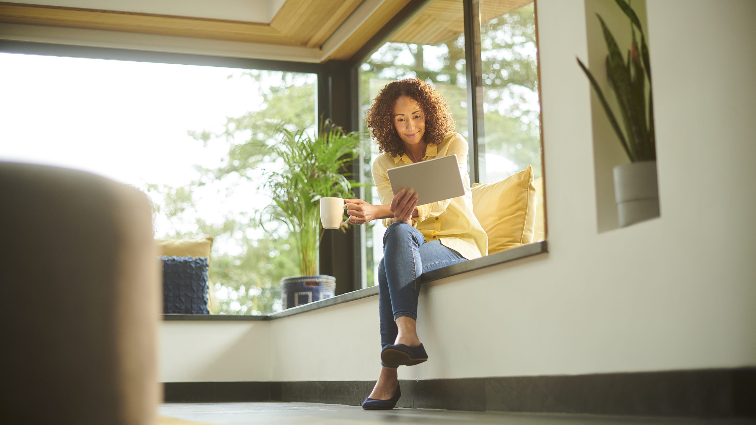 woman on tablet with cup of coffee