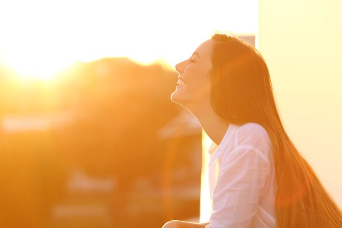 Woman smiling sunset balcony
