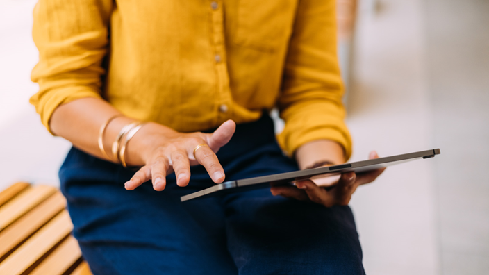 woman using tablet on bench