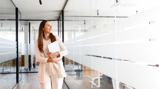 woman-walking-past-office-meeting-rooms