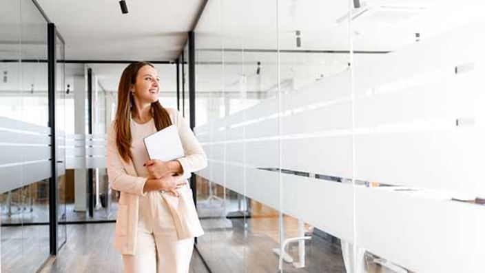 woman-walking-past-office-meeting-rooms
