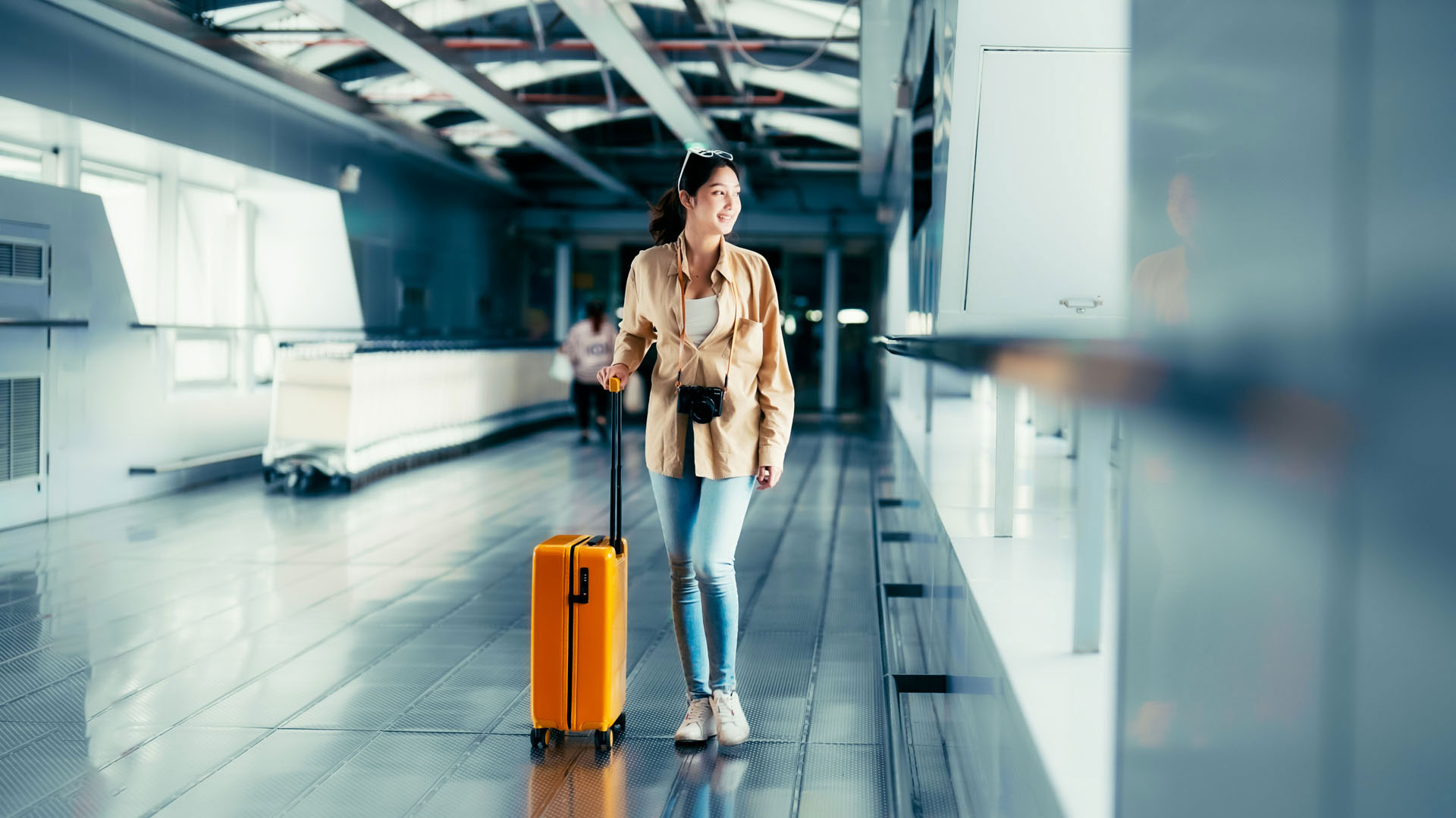 woman-walking-through-airport-with-suitcase