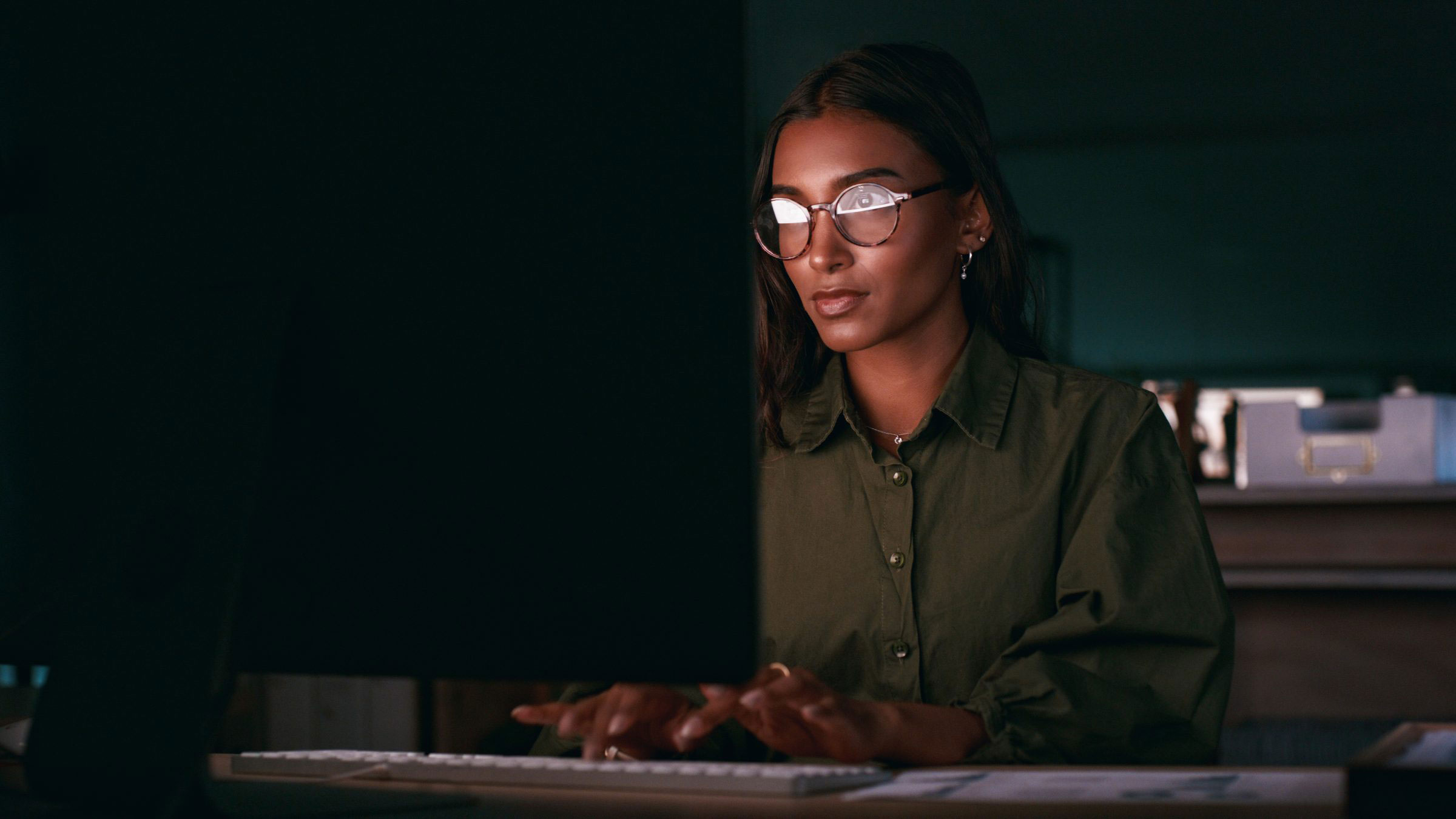 woman-working-on-laptop-at-night-in-the-office