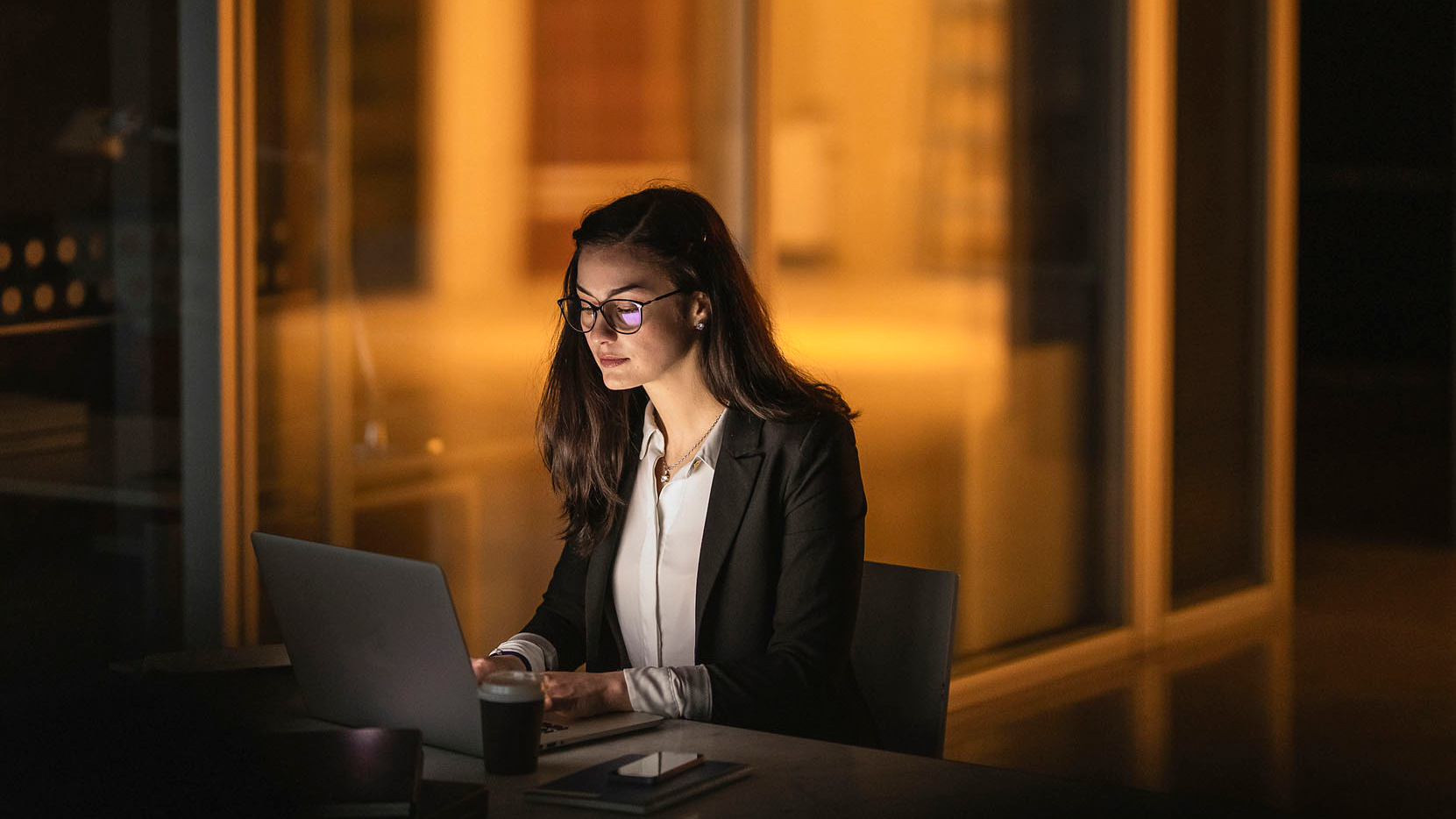 woman working on laptop in the office at night