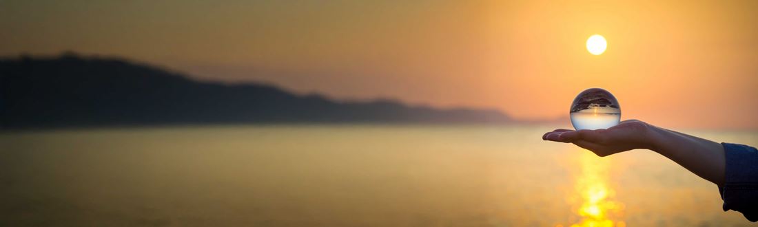 Globe being held at sunset