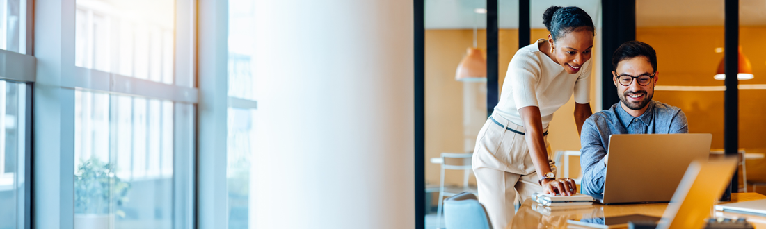 two people looking at a laptop in the office