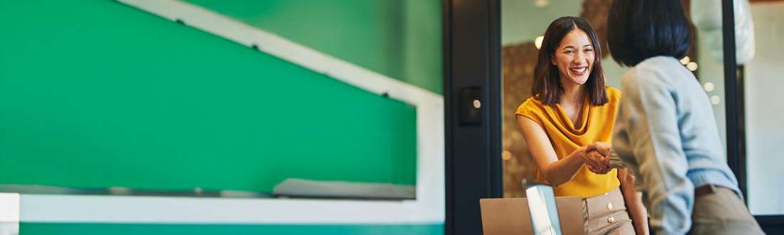 two women shaking hands
