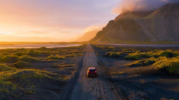 car driving toward mountain