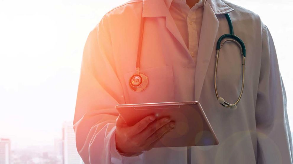 A doctor reviewing information on a tablet