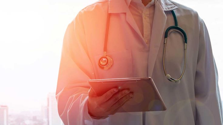 A doctor reviewing information on a tablet