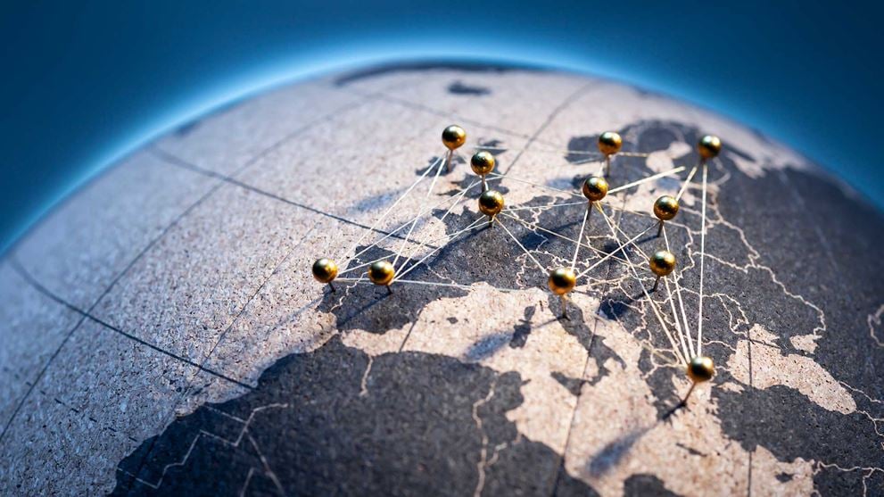 A close-up of a globe with location pins