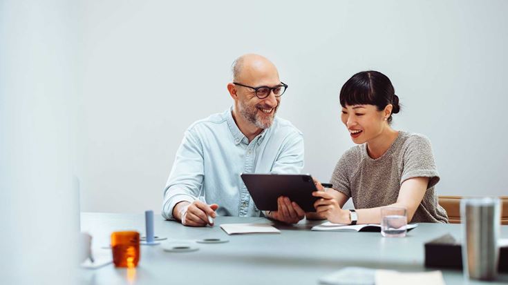Two colleagues looking at a tablet