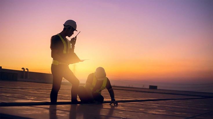 Two engineers working on a roof