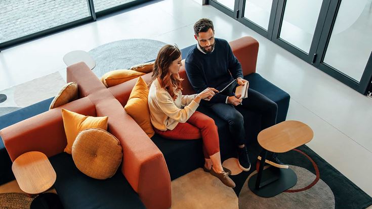 Two people working on a sofa