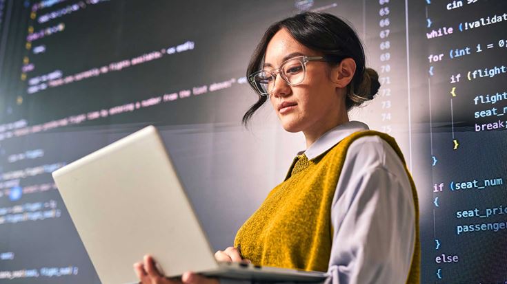 A woman coding on a laptop