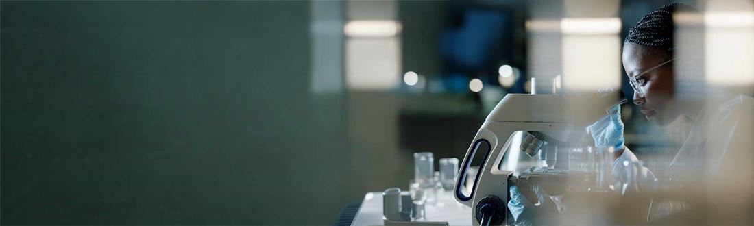 A scientist looking through a microscope