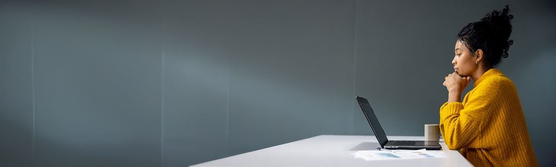 Professional woman sitting at desk working on laptop