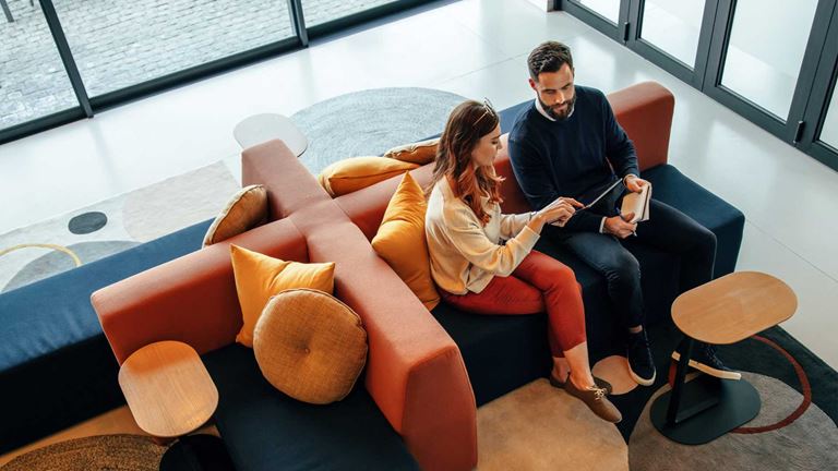 People-sitting-on-sofa-looking-at-ipad