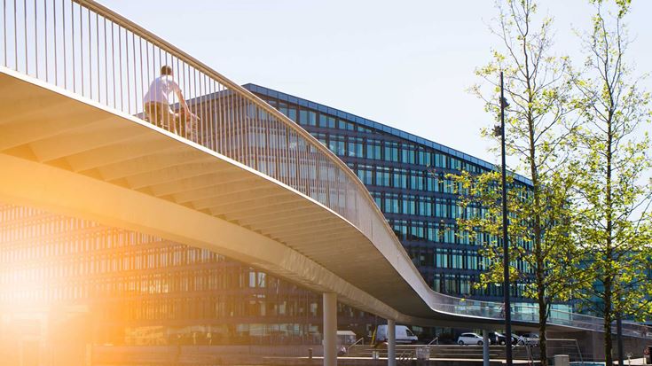 person-cycling-over-bridge