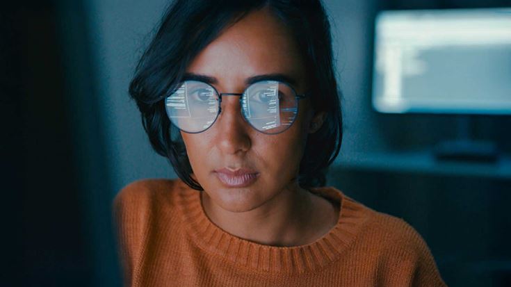 woman coding in dark