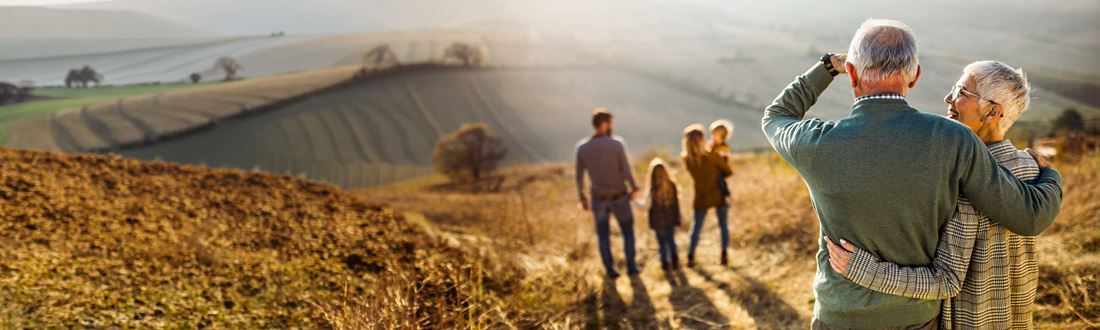 Senior couple standing together overlooking their family in nature
