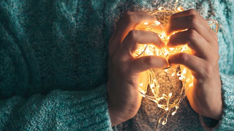 Hands-holding-a-heart-of-lights