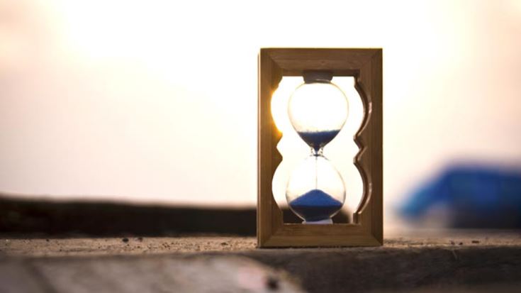 Hour glass on a wooden pier at sunset