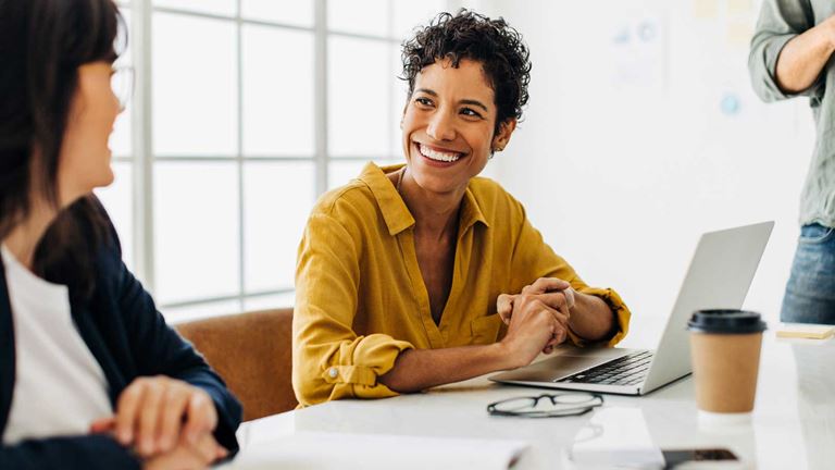 A businesswoman smiling in a financial team meeting