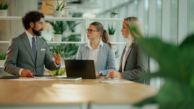 Three people talking at high table