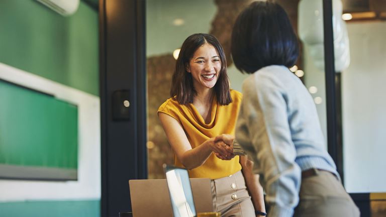 Two women shaking hands