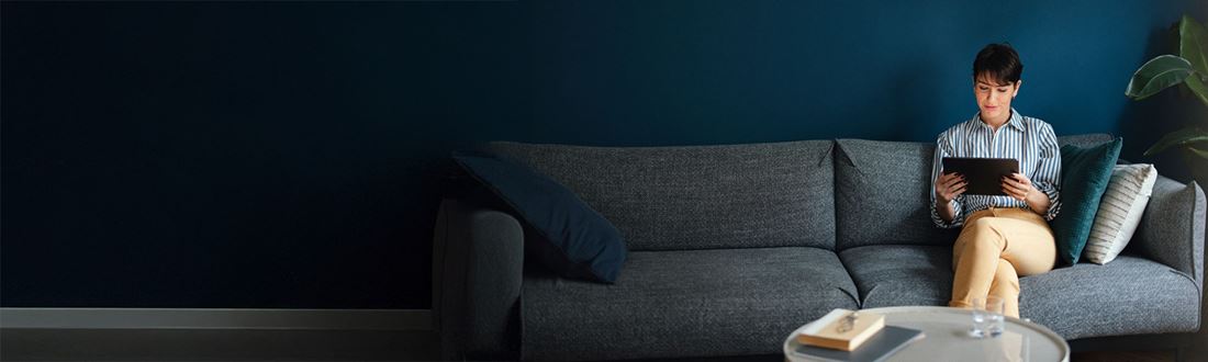 woman looking at tablet on sofa