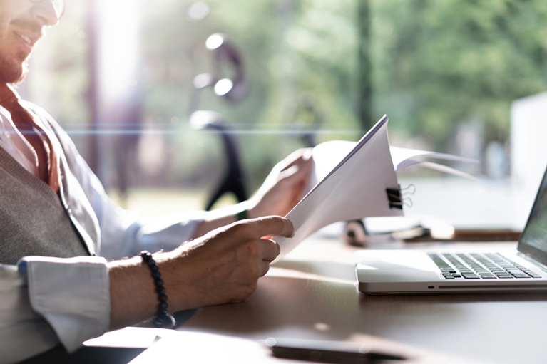 Professional comparing transaction records with supporting evidence