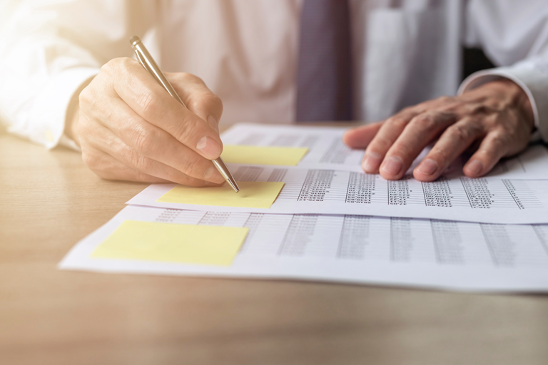Human resources and finance professional reviewing payroll records