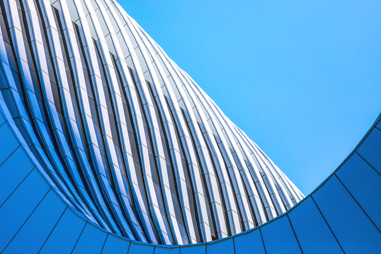 Abstract architectural forms and golden light representing coordinated corporate transformation and lasting performance.
