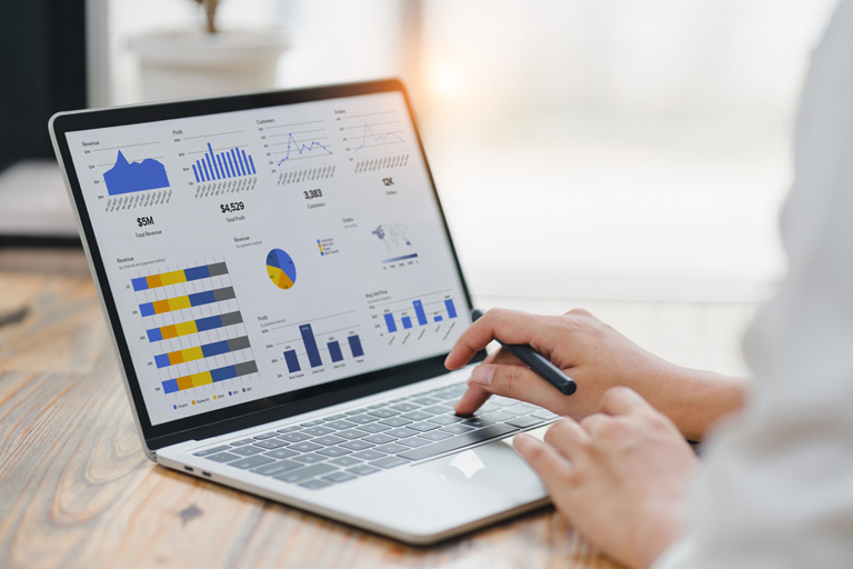 Professional analyzing financial data graphs charts on laptop display at a modern workspace Financial